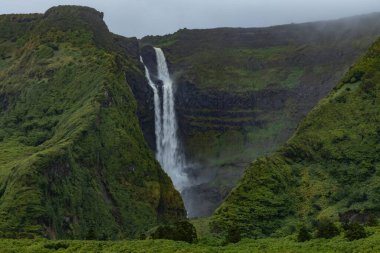 Breathtaking view of waterfall in the green mountains on Flores island Azores Portugal clipart