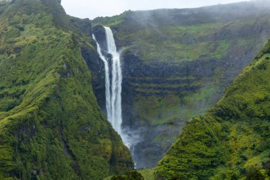 Flores Adası Azores Portekiz 'deki yeşil dağlardaki şelalenin nefes kesici manzarası.