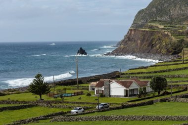 Portekiz 'in Azores Adaları' ndaki Atlantik Okyanusu kıyısındaki uçurumlardaki evleri nefes kesici bir şekilde görüyorsunuz.