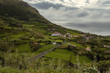 Taştan evleri olan küçük bir köy ve Flores adasında beyaz bir kilise Azores Portekiz
