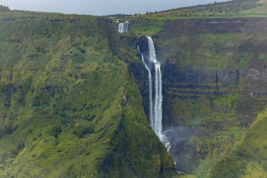 Flores Adası Azores Portekiz 'deki yeşil dağlardaki şelalenin nefes kesici manzarası.