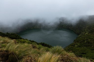 Flores Adası 'ndaki Azores Portekiz' de bir dağ gölünün üzerinde beyaz bulutlar dönüyor.