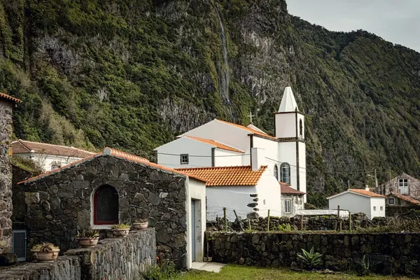 Taştan evleri olan küçük bir köy ve Flores adasında beyaz bir kilise Azores Portekiz