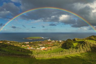 Azores 'teki Sao Jorge Adası' nda gökkuşağında gökkuşağı ve deniz fenerinin nefes kesici manzarası Portekiz 'de