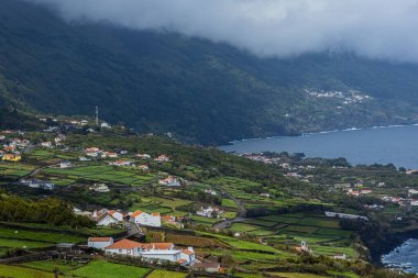 Küçük köyün nefes kesici manzarası ve Pico Adası 'ndaki Azores Portekiz uçurumundan yeşil çayırlar.
