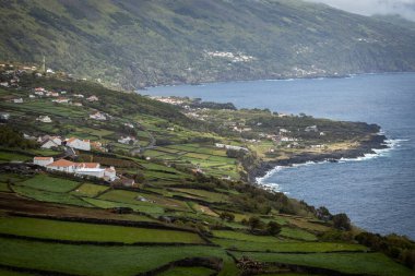 Küçük köyün nefes kesici manzarası ve Pico Adası 'ndaki Azores Portekiz uçurumundan yeşil çayırlar.