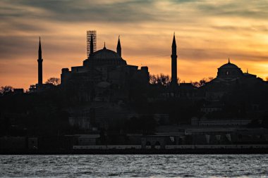 İstanbul Sultanahmet 'in sultanahmet bölgesinde kayıklar, İstanbul Camii' nin minare siluetinde güzel bir gün batımı