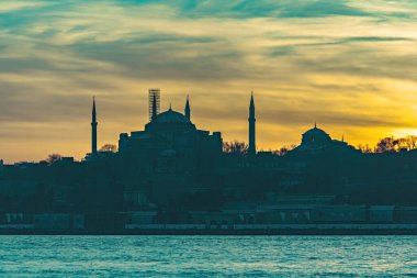 İstanbul Sultanahmet 'in sultanahmet bölgesinde kayıklar, İstanbul Camii' nin minare siluetinde güzel bir gün batımı