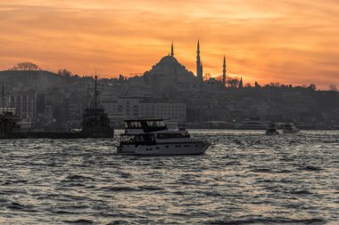 İstanbul Sultanahmet 'in sultanahmet bölgesinde kayıklar, İstanbul Camii' nin minare siluetinde güzel bir gün batımı