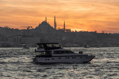 İstanbul Sultanahmet 'in sultanahmet bölgesinde kayıklar, İstanbul Camii' nin minare siluetinde güzel bir gün batımı