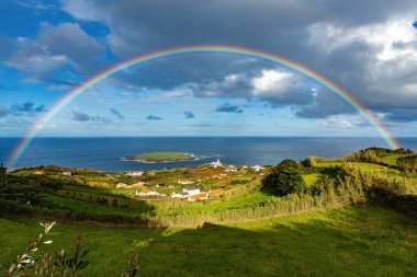 Azores 'teki Sao Jorge Adası' nda gökkuşağında gökkuşağı ve deniz fenerinin nefes kesici manzarası Portekiz 'de