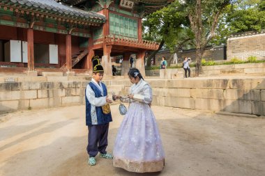 Couple wearing traditional Korean costume Hanbok at Deoksugung Palace in Seoul South Korea clipart