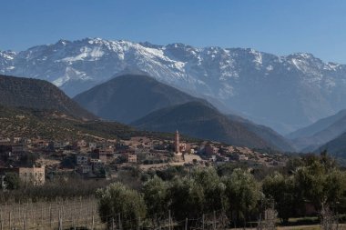 Büyük Atlat Dağları ve Orica Vadisi manzaralı geleneksel evler ve arka planda minare karlı dağlar