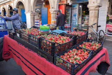 Arap adam Essaouira Medina 'da eski Fas' ta taze çilek satıyor.
