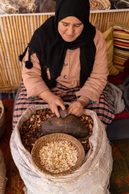 Argan petrol fabrikasındaki Argan meyvelerini soyan kadınların ellerini kapatın.