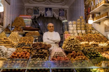 Medine 'nin eski kenti Marakeş Fas' taki geleneksel pazarda baharat, ot ve şeker satan Faslı bir adam.