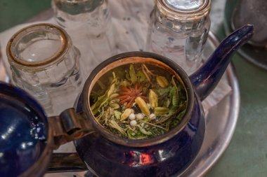 Berber çaydanlığının üst manzarası otlarla, kardamon, anason ve nane gibi baharatlarla dolu.