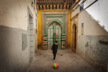 Küçük Faslı çocuk Essaouira Fas 'ın Medine şehrinde topla oynuyor.