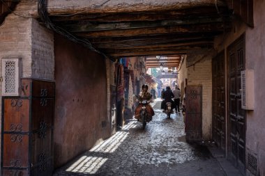 Dar yol kemeri ve Medina Marakeş Fas 'ta markette scooter kullanan adam.