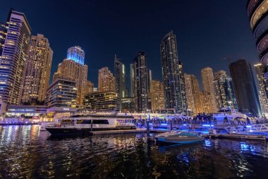 Dubai Marina at night with boats and city lights UAE clipart