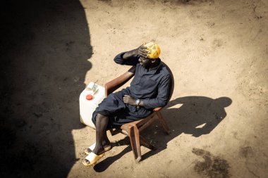 Afrikalı bir adam Senegal 'in yukarısından evinin bahçesine bakıyor.