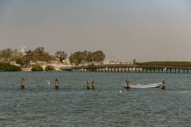 Joal Fadiouth sahilinde balıkçı tekneleri Senegal 'in deniz kabuğu adası.