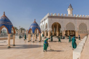 Touba Senegal Büyük Camii 'nin bahçesini temizleyen gönüllü bir kadın.