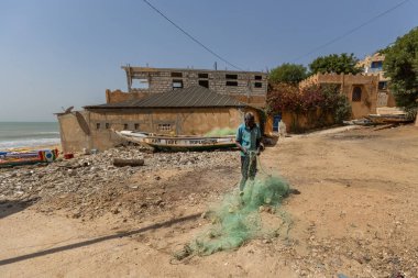 Senegali balıkçıları Popenguine Senegal sahilindeki ağları çözer.