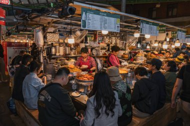 Gwangjang Pazarı 'ndaki insanlar Seul' deki en büyük gıda pazarlarından birinde yemek yiyorlar.