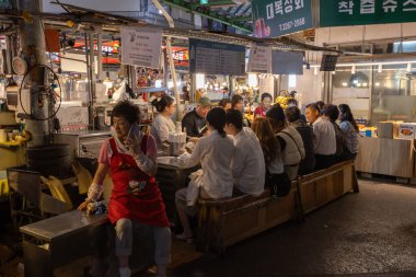 Gwangjang Pazarı 'ndaki insanlar Seul' deki en büyük gıda pazarlarından birinde yemek yiyorlar.