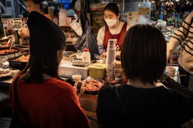 Gwangjang Pazarı 'ndaki insanlar Seul' deki en büyük gıda pazarlarından birinde yemek yiyorlar.