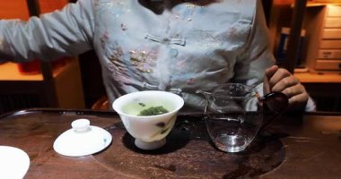 Çin çay seremonisi. Tanınmayan bir kadın. Görünmez bir yüz. Çin çayını tadıyor.