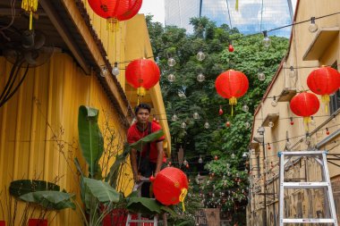 Kuala Lumpur Malezya 'da Çin mahallesinin sokaklarına Çin fenerleri asan Çinli bir adam.