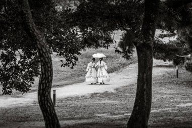 Gyengju, Güney Kore 'de geleneksel Hanbok giysileri içinde parkta yürüyen iki genç kadın.