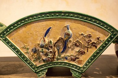 Macau 'daki eski Çin evinde kuş ve çiçek desenli seramik bir Çin yelpazesi. 