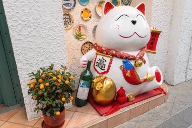 Maneki-neko 'nun heykeli Macau şehrinin sokaklarındaki şanslı kedi.