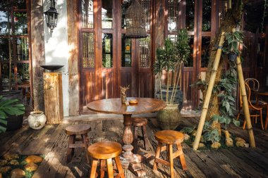 Bali 'de geleneksel ahşap bir kafe olan taşralı açık alan, yemyeşil, doğal dokular ve klasik cazibeyle çevrili.