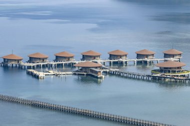 Endonezya 'nın Labuan Bajo kasabası Komodo' da su üzerinde kulübeleri olan tepelerin ve körfezin havadan görüntüsü.