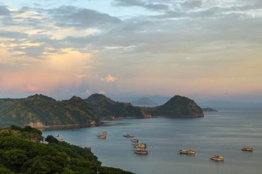 Endonezya 'nın Labuan Bajo kasabası Komodo' da su üzerinde kulübeleri olan tepelerin ve körfezin havadan görüntüsü.
