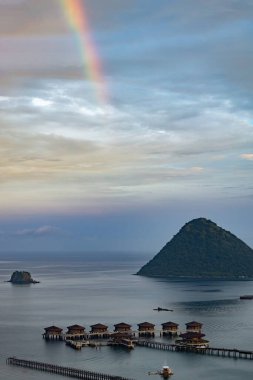 Endonezya 'nın Labuan Bajo kasabası Komodo' da su üzerinde kulübeleri olan tepelerin ve körfezin havadan görüntüsü.