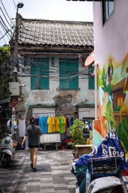 Bangkok 'un Talat Noi bölgesinde eski evler ve motosikletler park halinde.
