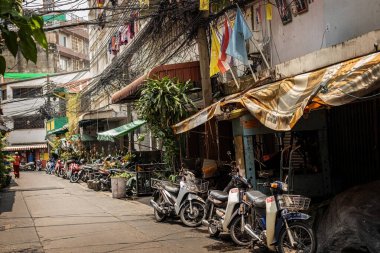 Talat Noi bölgesindeki Bangkok sokağı. Eski Bangkok Tayland 'da geleneksel sokak manzarası boyunca park edilmiş eski evler ve motosikletler.