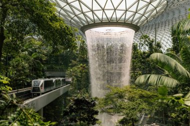 Jewel Yağmur Girdabı Şelalesi ve Singapur 'daki Changi Singapur havaalanında çalışan tren.