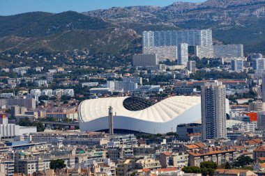 Orange Velodrome, Marsilya ikonik futbol stadyumu, şehir manzarası ve güney Fransa tepeleri ile çevrili.