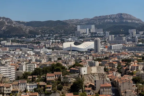 Orange Velodrome, Marsilya ikonik futbol stadyumu, şehir manzarası ve güney Fransa tepeleri ile çevrili.