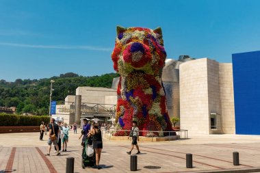 BILBAO, SPAIN - 3 Temmuz 2024: Çiçeklerle kaplı köpek yavrusu heykeli, İspanya 'nın Bilbao kentindeki Guggenheim Müzesi' nin dışında bir sanat eseri