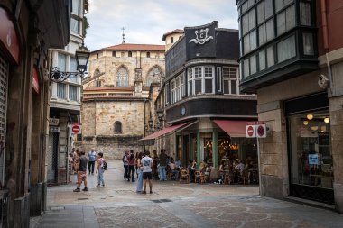 BILBAO, SPAIN - 20 Temmuz 2024: Casco Viejo, Bilbao 's Old Town' da sokak manzarası, arka planda tarihi San Antn Kilisesi ve yerel halk canlı kafe kültürünün tadını çıkarıyor