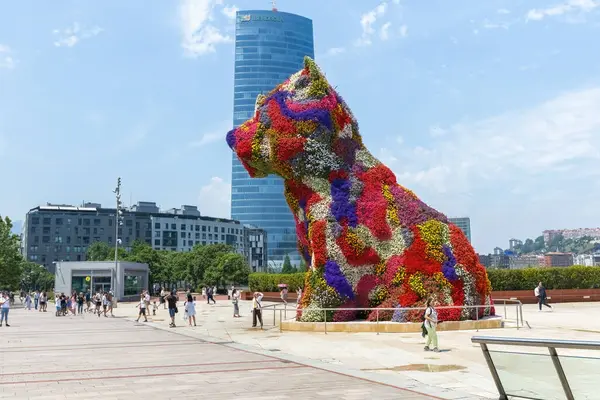 BILBAO, SPAIN - 3 Temmuz 2024: Çiçeklerle kaplı köpek yavrusu heykeli, İspanya 'nın Bilbao kentindeki Guggenheim Müzesi' nin dışında bir sanat eseri
