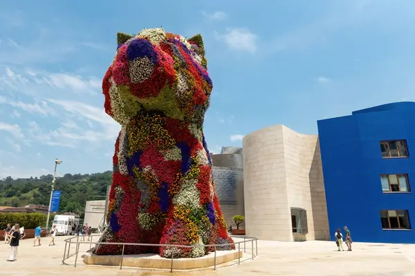 BILBAO, SPAIN - 3 Temmuz 2024: Çiçeklerle kaplı köpek yavrusu heykeli, İspanya 'nın Bilbao kentindeki Guggenheim Müzesi' nin dışında bir sanat eseri