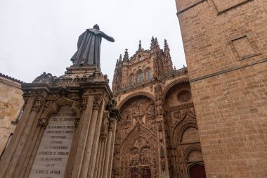 SALAMANCA, İspanya - 3 Temmuz 2024: Fray Luis de Len 'in heykeli Yeni Salamanca Katedrali' nin önünde duruyor Gotik ve Barok mimarisinin bir başyapıtı